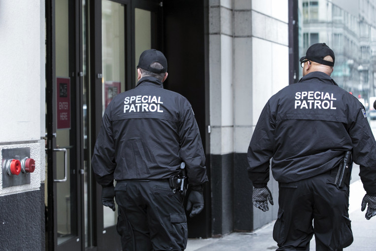 Two armed private security guards, hired by the Chicago Loop Alliance, walk into a store as they patrol State Street, Thursday, March 1, 2018. An organization of local businesses and organizations called the Chicago Loop Alliance hired a security company to patrol an area of Chicago where police are often busy racing from call to call and may not be able to respond as quickly as local businesses would like. Chicago Police Superintendent Eddie Johnson says he isn't concerned about the guards and explains that it isn't unusual for places like malls and high rises to hire private security firms. (Ashlee Rezin /Chicago Sun-Times via AP) ORG XMIT: ILCHS104